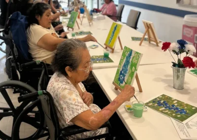 Residents engaged in a group art and painting activity at a table together
