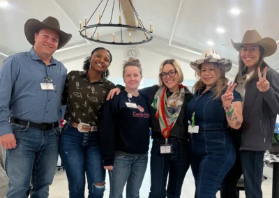 Staff in cowboy hats pose for a Western-themed group event photo.