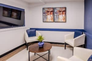 Waiting area with three chairs and a TV at Castle Hills Rehab & Care Center