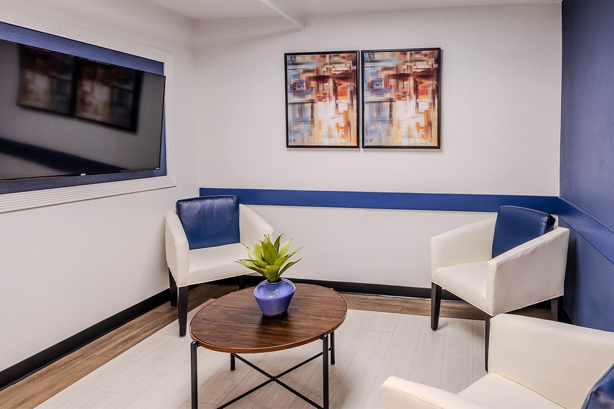 Waiting area with three chairs and a TV at Castle Hills Rehab & Care Center